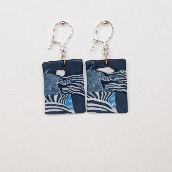 Mainly black and white porcelain earrings, with blue accent.